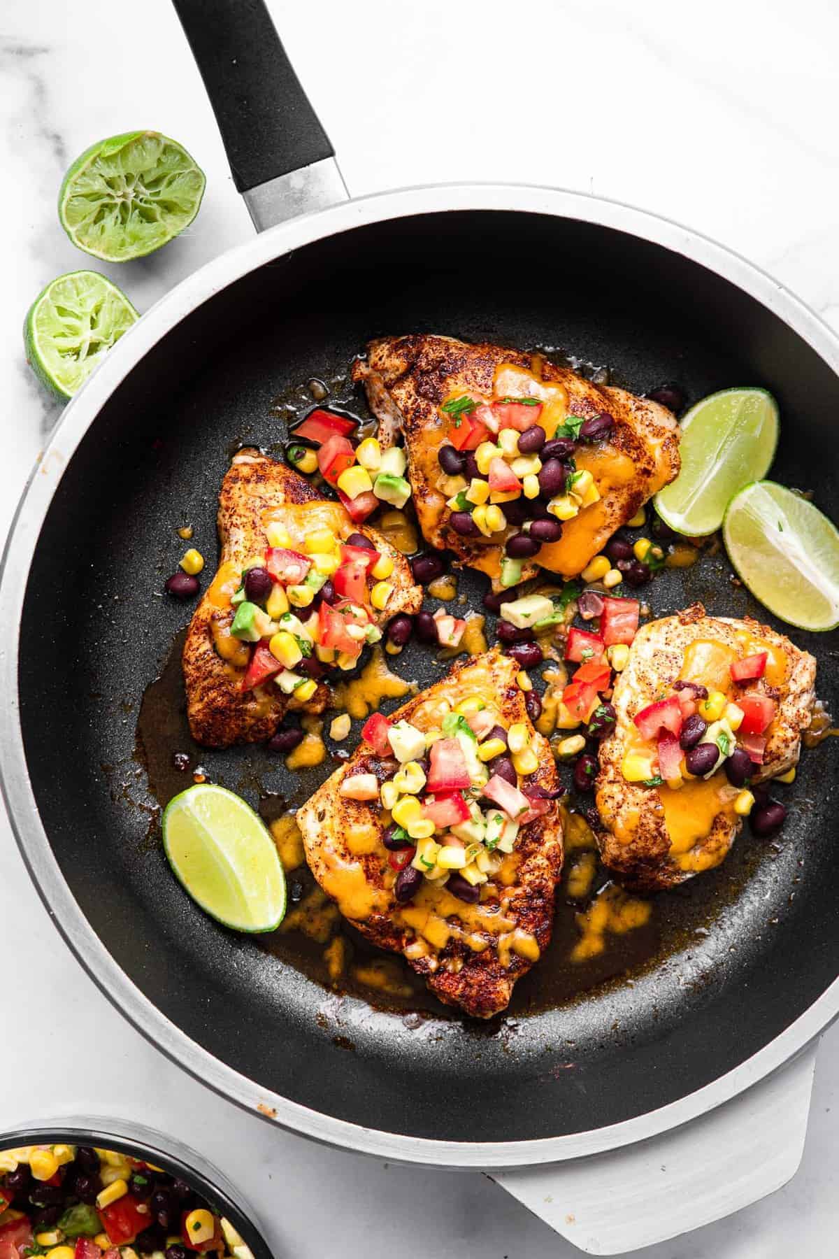 Santa Fe Chicken - This Santa Fe Chicken is an easy, weeknight dinner that is naturally gluten free and healthy! This will please even the pickiest of eaters! | #Foodfaithfitness | #glutenfree #healthy #dinner #chickendinner #kidfriendly santa fe chicken in a skillet with cheese and black bean salsa