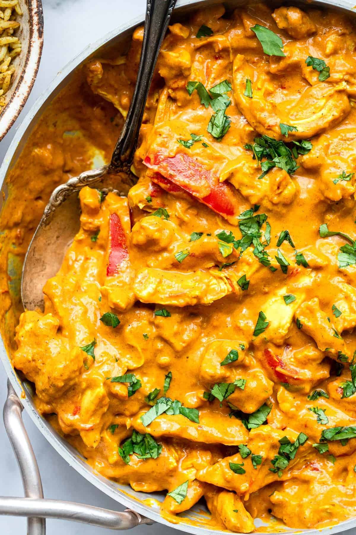 Whole30 Coconut Paleo Chicken Curry - This low carb Curry is an easy weeknight dinner with bold, Indian flavor. Simple to make, great for meal prep and low carb, keto and whole30 friendly too! | #Foodfaithfitness | #Glutenfree #Paleo #whole30 #lowcarb #keto close up photo of paleo chicken curry in a serving bowl with cilantro on top