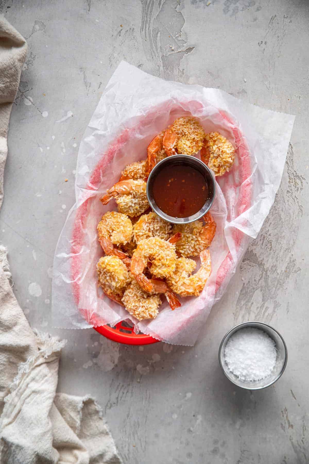 Air Fryer Coconut Shrimp - This easy Air Fryer Coconut Shrimp is just as crispy as you expect, but without the deep frying! A healthy side or dinner with a gluten free option! | #Foodfaithfitness | #glutenfree #airfryer #healthy Air fryer fried shrimp in a basket with sauce and coconut flakes