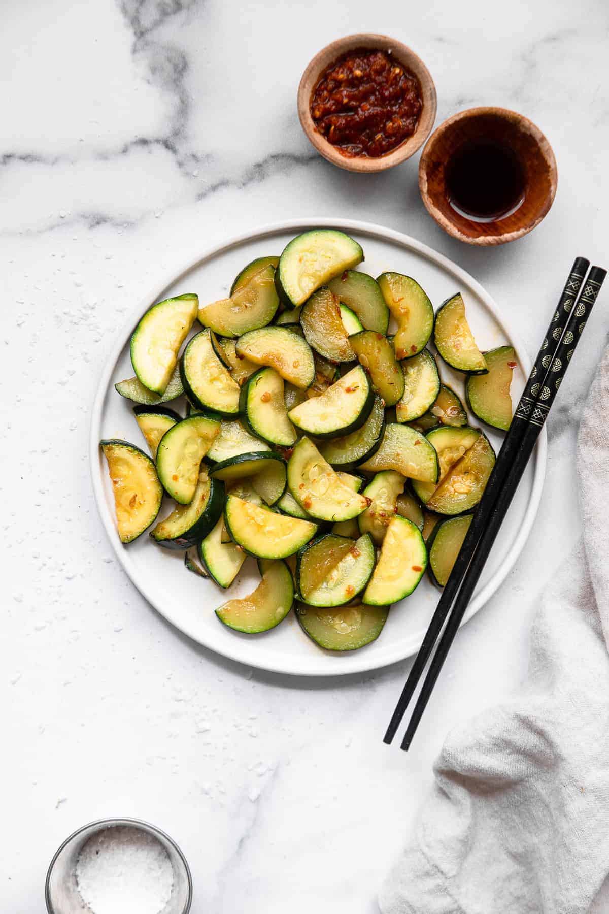 Zucchini Stir Fry on a large flat plate with chopsticks