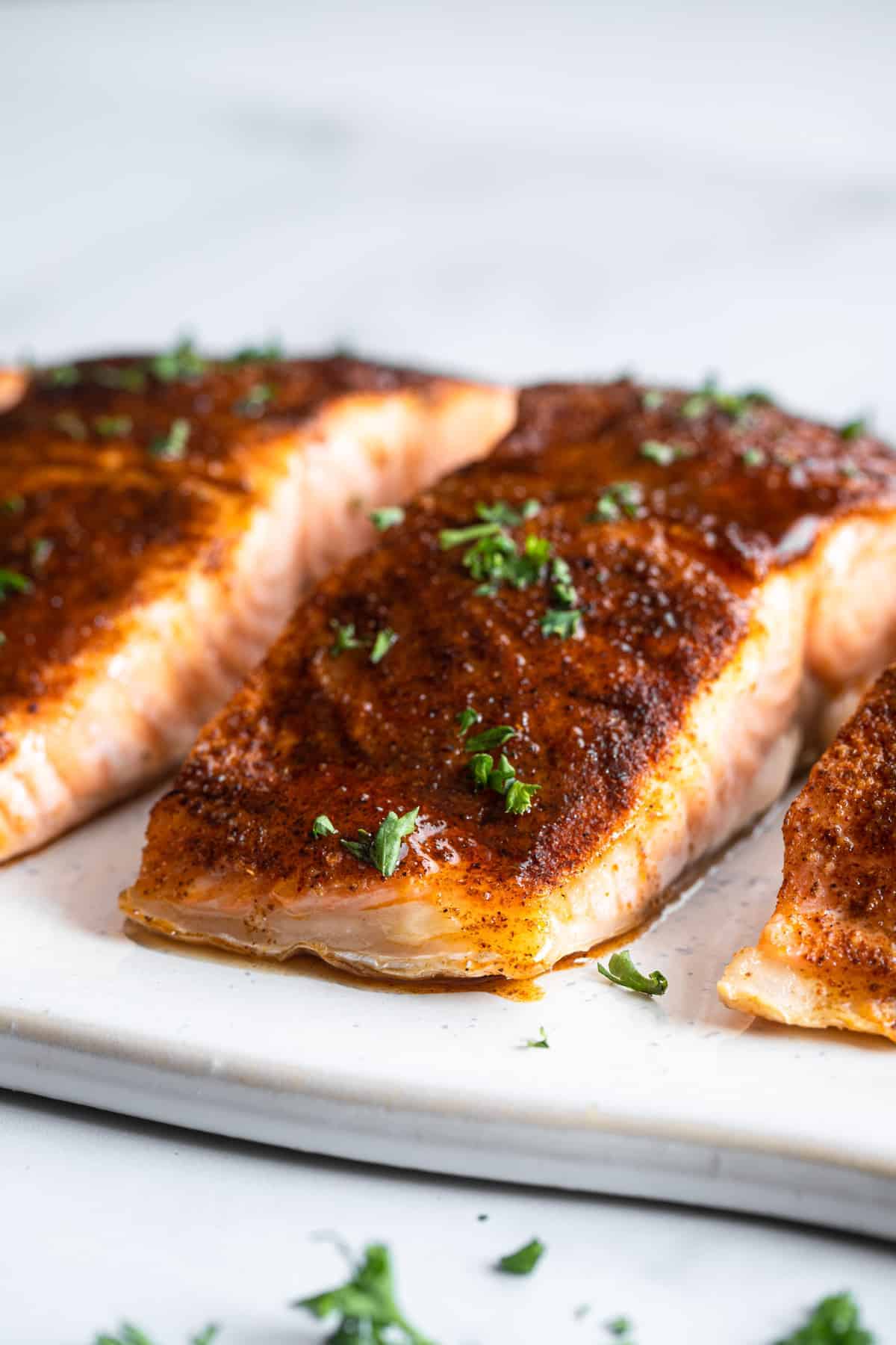 Baked Honey Cajun Salmon - This Baked Honey Cajun Salmon is spicy, sweet and only 4 Ingredients! A 15 minute, weeknight dinner that is healthy, gluten free and paleo friendly! | #Foodfaithfitness | #glutenfree #paleo #healthy #lowcarb Cajun Salmon side view close up of fillets