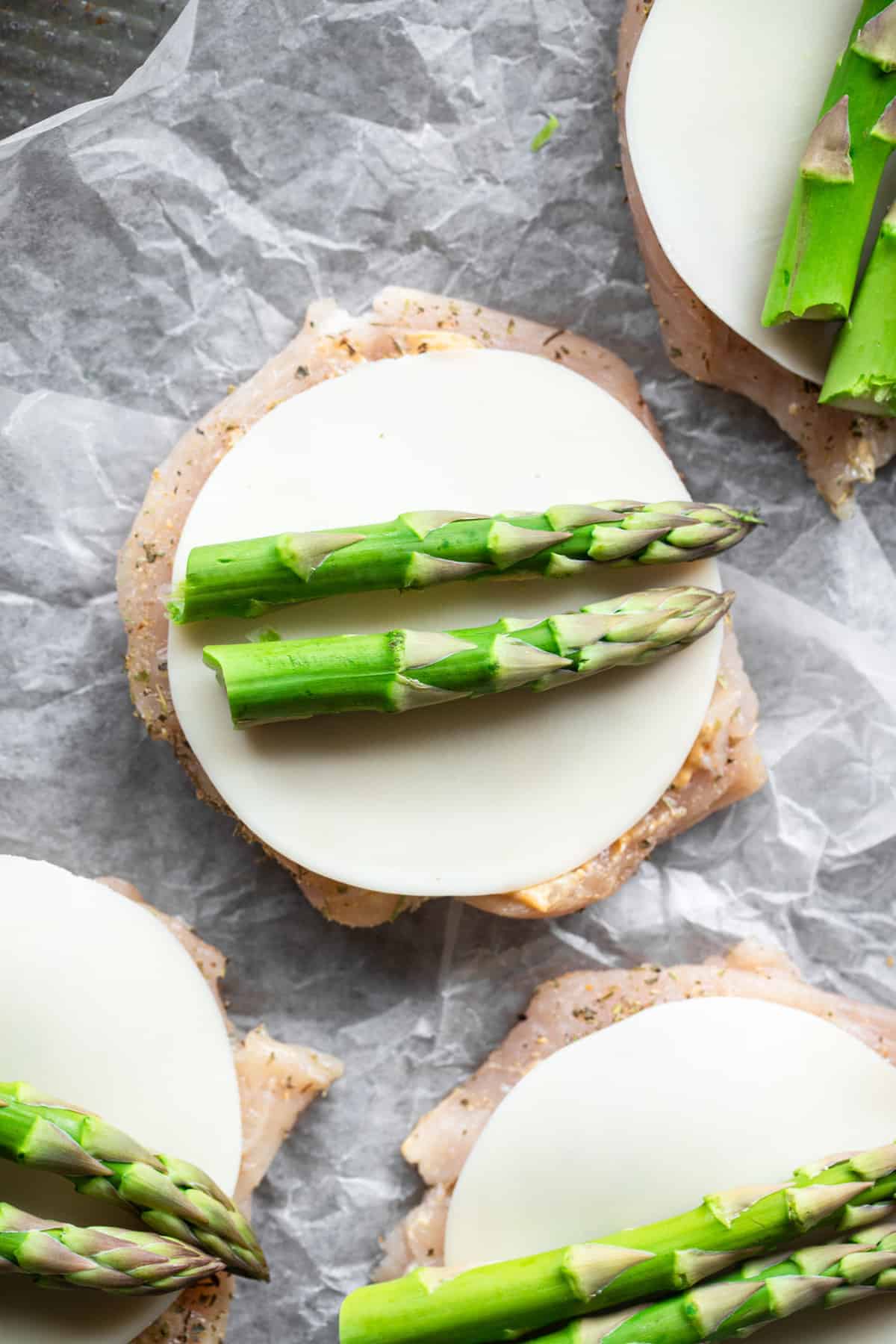 Low Carb Asparagus Stuffed Chicken - This Asparagus Stuffed Chicken Breast is a super easy meal that feels fancy! Naturally gluten free, low carb, healthy and tasty too! | #Foodfaithfitness | #lowcarb #keto #glutenfree #healthy asparagus chicken prepared and ready to be bakes