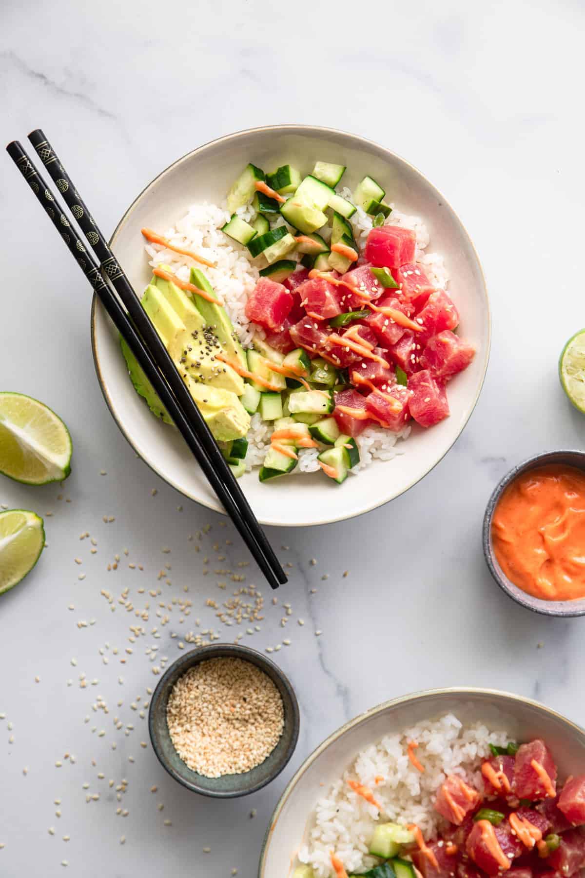 Spicy Ahi Tuna Poke Bowl - This Spicy Ahi Tuna Poke Bowl Recipe is an easy, healthy dinner that is just as good as restaurants but at home! Naturally gluten free and protein packed! | #Foodfaithfitness | #glutenfree #dairyfree #healthy #pokebowl tuna poke bowl recipe on a bowl with chopsticks and sauces