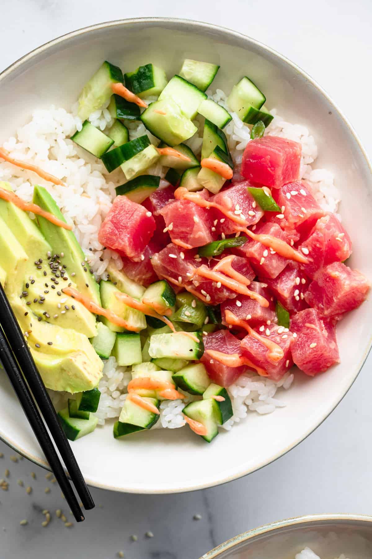 Spicy Ahi Tuna Poke Bowl - This Spicy Ahi Tuna Poke Bowl Recipe is an easy, healthy dinner that is just as good as restaurants but at home! Naturally gluten free and protein packed! | #Foodfaithfitness | #glutenfree #dairyfree #healthy #pokebowl Tuna poke bowl close up in serving bowl with chopsticks