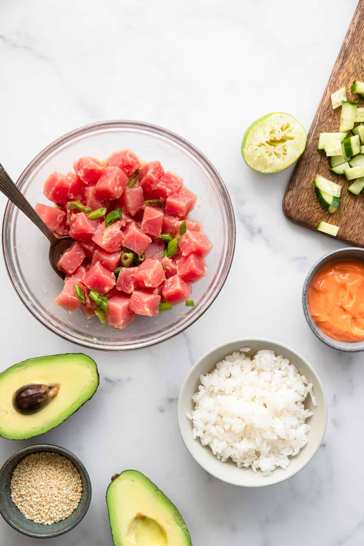 Spicy Ahi Tuna Poke Bowl - This Spicy Ahi Tuna Poke Bowl Recipe is an easy, healthy dinner that is just as good as restaurants but at home! Naturally gluten free and protein packed! | #Foodfaithfitness | #glutenfree #dairyfree #healthy #pokebowl tuna bowl ingredients being prepped