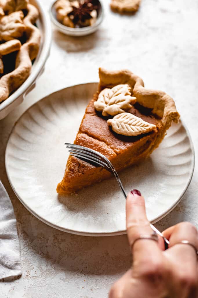 One slice of Creamy Vegan Butternut Squash Pie on a plate being eaten