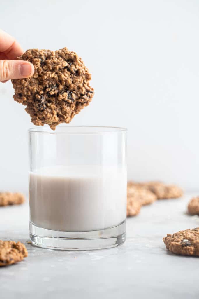 one Healthy Oatmeal Cookies being dipped into a glass of milk