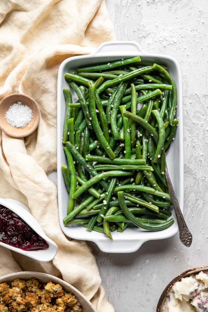 Instant Pot Green Beans in a serving dish on a table with spoon