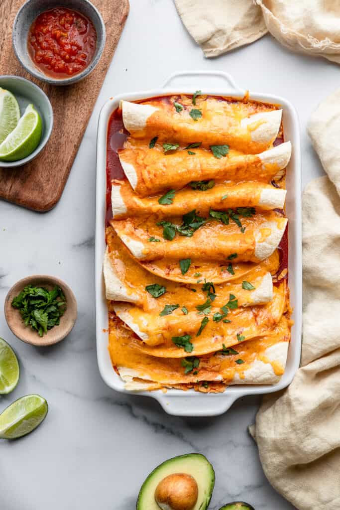 Instant Pot Chicken Enchilada in a dish on a table with toppings on the side