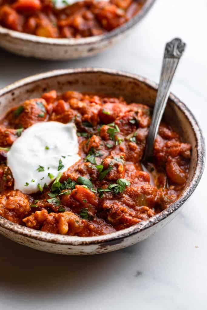 a bowl of Turkey Pumpkin Chili with sour cream on top