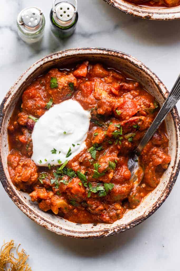 one bowl of Turkey Pumpkin Chili with a spoon and toppings