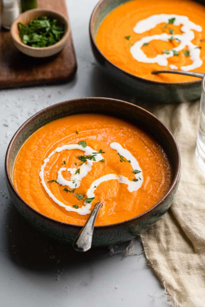 two bowls of Carrot Ginger Soup with spoons
