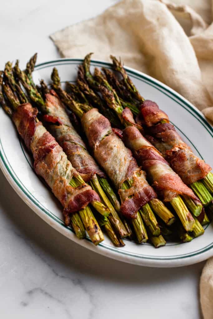 Air Fryer Bacon Wrapped Asparagus on a oval plate