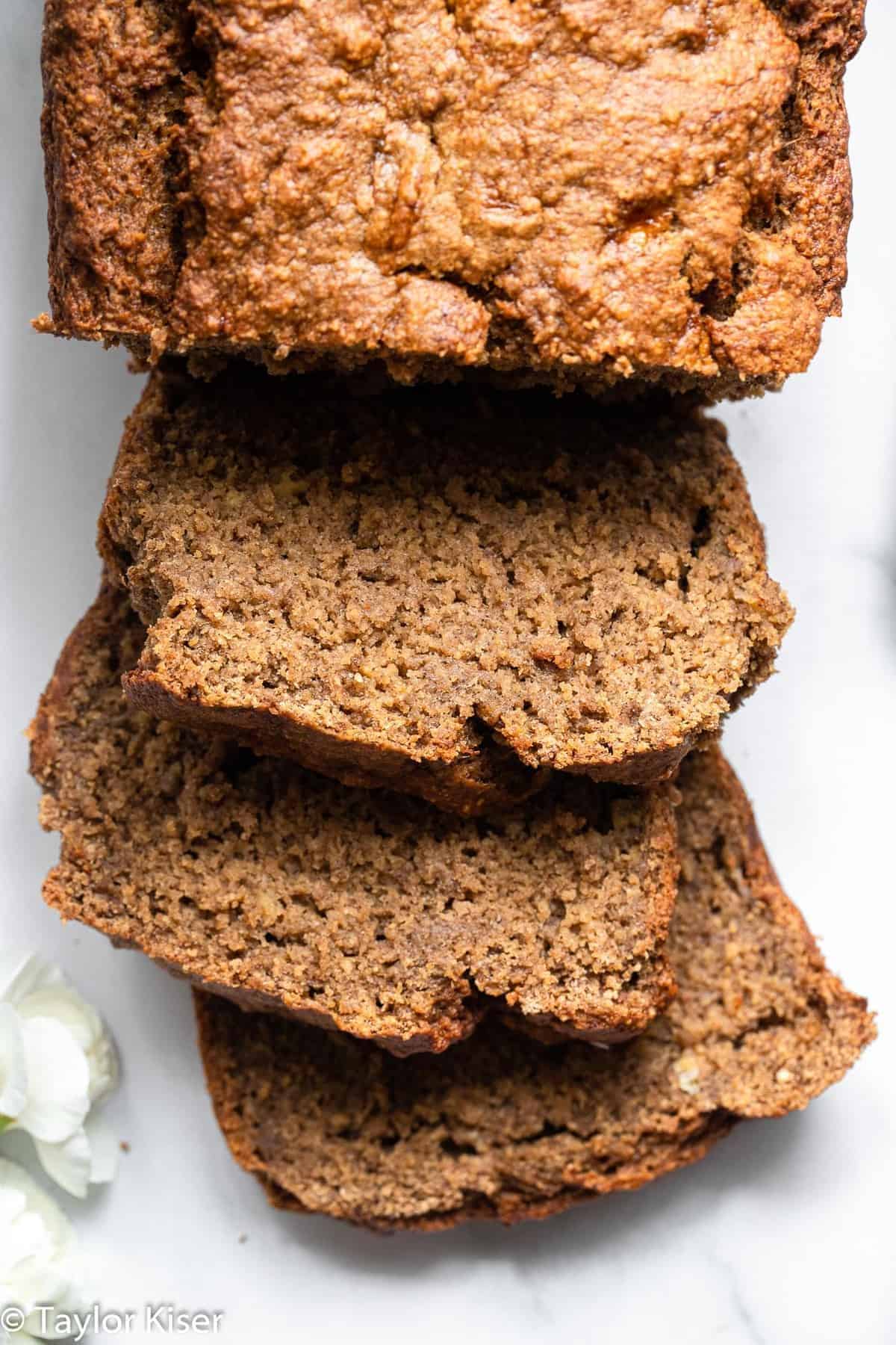 Vegan Gluten Free Banana Bread - This Vegan Gluten Free Banana Bread is so soft, chewy and perfectly sweet you would never know it's gluten, dairy and egg free and healthy! | #Foodfaithfitness | #Glutenfree #vegan #dairyfree #eggfree #healthy vegan gluten free banana bread with 3 slices taken out of it