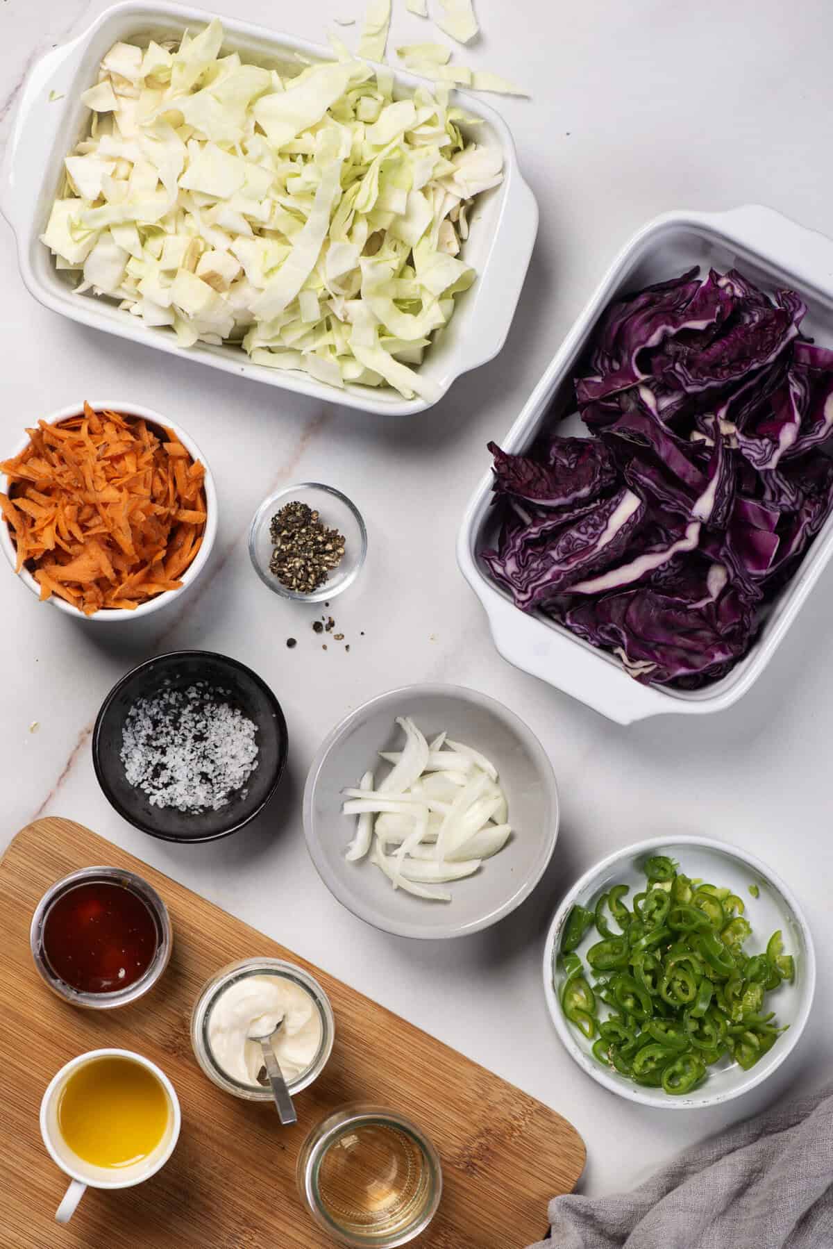 Ingredients for Jalape&ntilde;o Coleslaw: green and red cabbage, shredded carrots, sliced jalape&ntilde;os, and onion.