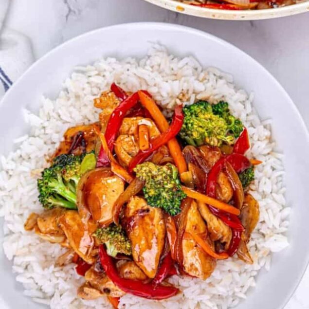 Healthy chicken stir-fry with broccoli, red bell peppers, and carrots served over white rice for a nutritious, flavorful meal. Perfect for balanced eating and weight management.