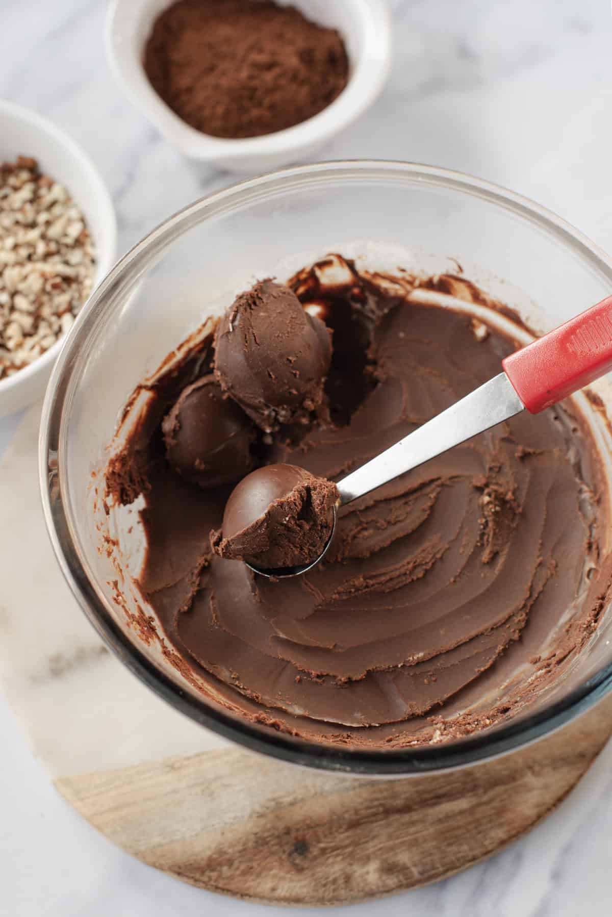 chocolate truffles being scooped with a melon baller