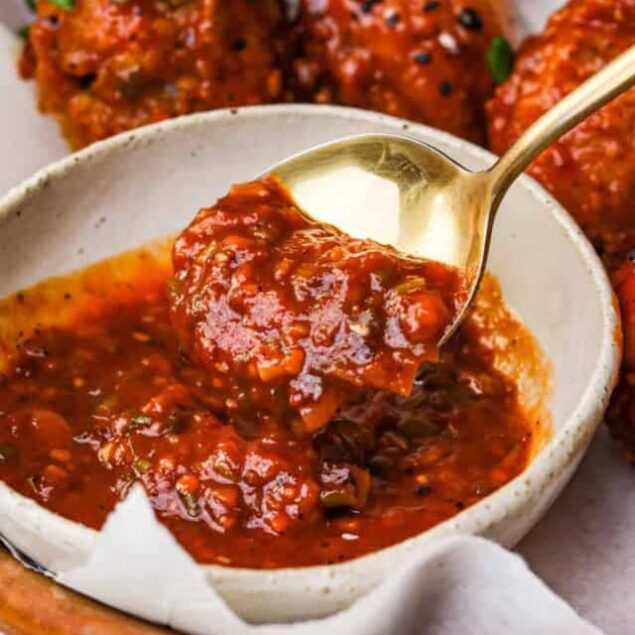 Savory homemade chicken meatballs in rich tomato sauce served with fresh herbs and black sesame seeds. Perfect for healthy meals, meal prep, or comfort food enthusiasts.
