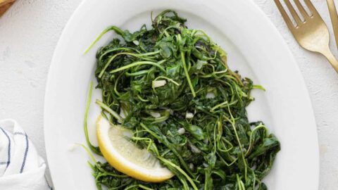 Plated sautéed arugula with lemon garnish