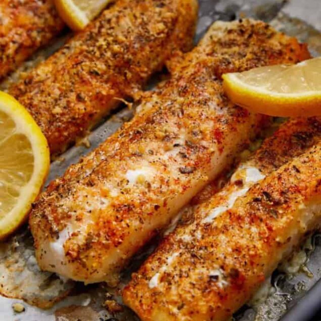 Crispy baked lemon garlic tilapia fillets with fresh lemon wedges, healthy seafood recipe, easy nutritious dinner, low-calorie fish dish, Food Faith Fitness.