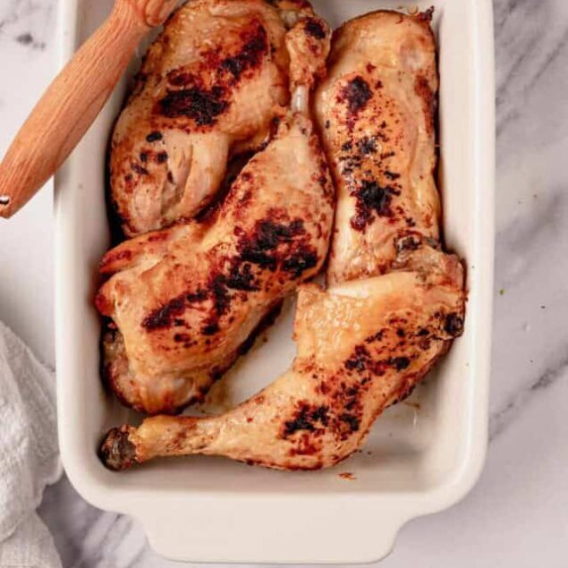 Grilled chicken drumsticks in a white baking dish on marble surface, healthy high-protein meal, perfect for meal prep, clean eating, easy dinner ideas, and nutritious recipes from Food Faith Fitness.