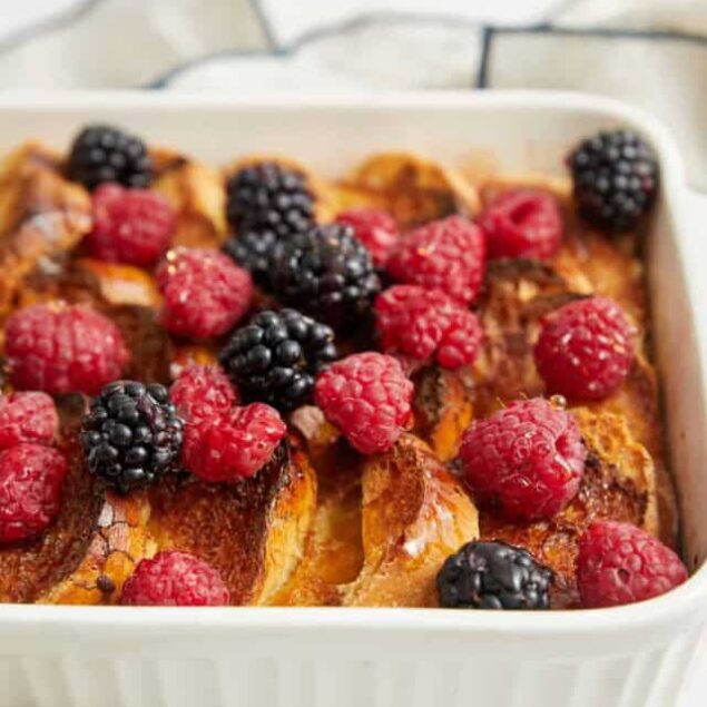 Fresh berry-topped baked French toast casserole with raspberries and blackberries, a delicious healthy breakfast recipe from Food Faith Fitness.