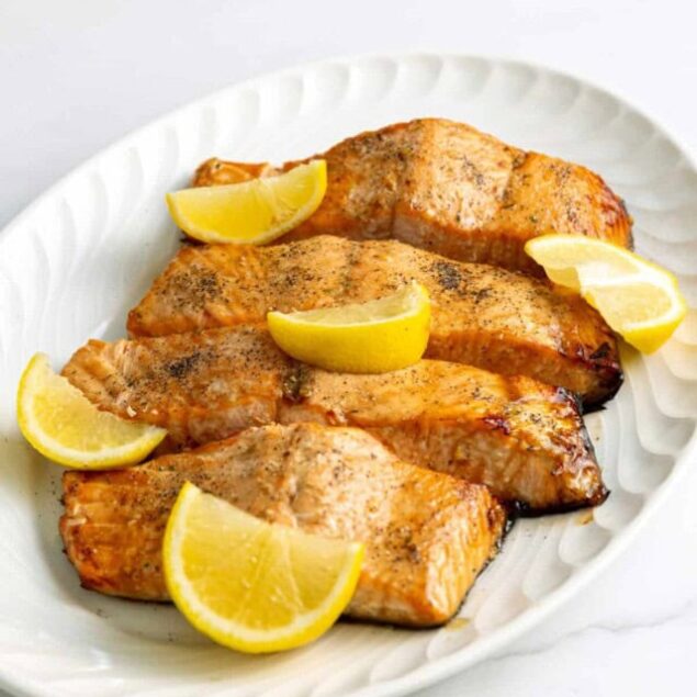 Grilled salmon fillets with lemon wedges, healthy seafood dish, high-protein meal, gluten-free dinner, nutritious fish recipes.