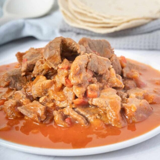 Savory beef stew with tender meat and vegetables in rich broth, served with warm flatbread, perfect for healthy comfort food and meal prep.