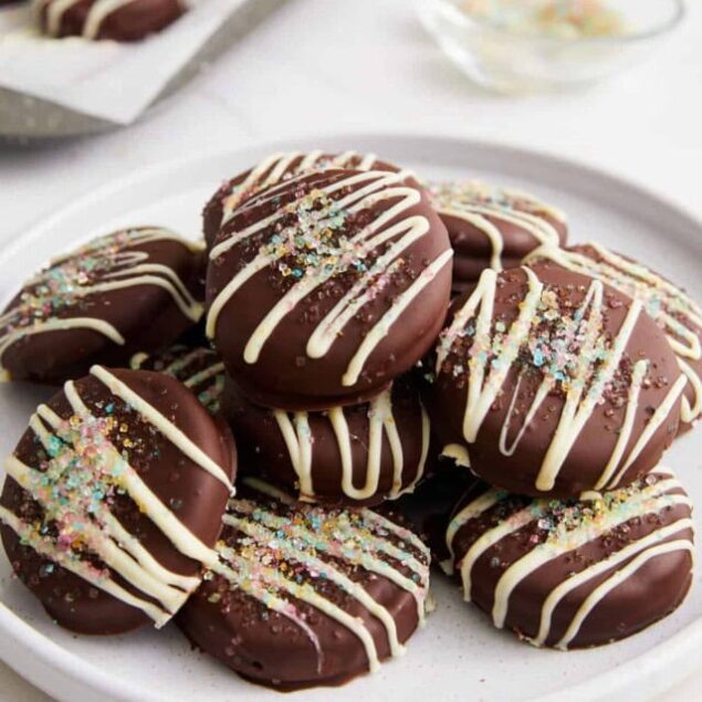 Chocolate cake pops covered in rich chocolate, drizzled with white chocolate, and topped with colorful sprinkles, perfect for healthy treats and dessert ideas from Food Faith Fitness.