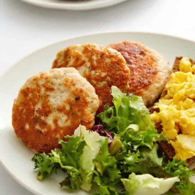 Fluffy homemade chicken meatballs with fresh green salad and scrambled eggs on a white plate, healthy breakfast or dinner option, nutritious meal idea, high-protein comfort food, food faith fitness.