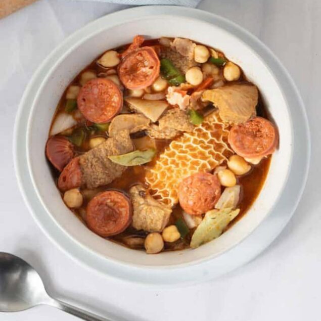 Savory chicken and sausage vegetable soup with chickpeas and fresh herbs, perfect for healthy eating and meal prep.