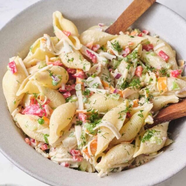 Creamy pasta salad with fresh vegetables and herbs, perfect for healthy meals and easy snack options.
