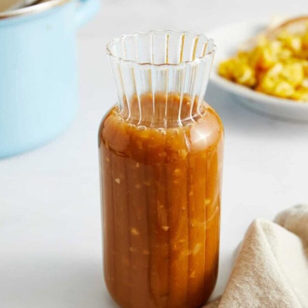 Creamy homemade caramel sauce in a glass jar, perfect for desserts and added flavor.