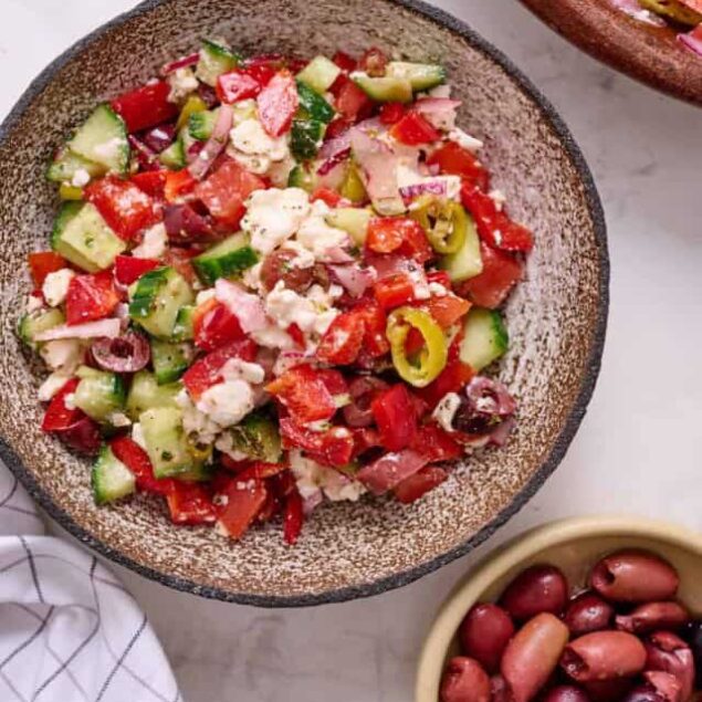 Fresh Mediterranean vegetable salad with cucumbers, tomatoes, red onions, olives, and feta cheese, perfect for healthy eating and weight loss.