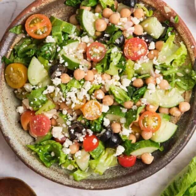 Fresh veggie chickpea salad with cherry tomatoes, cucumbers, olives, feta cheese, and chickpeas, perfect for healthy eating and weight loss.