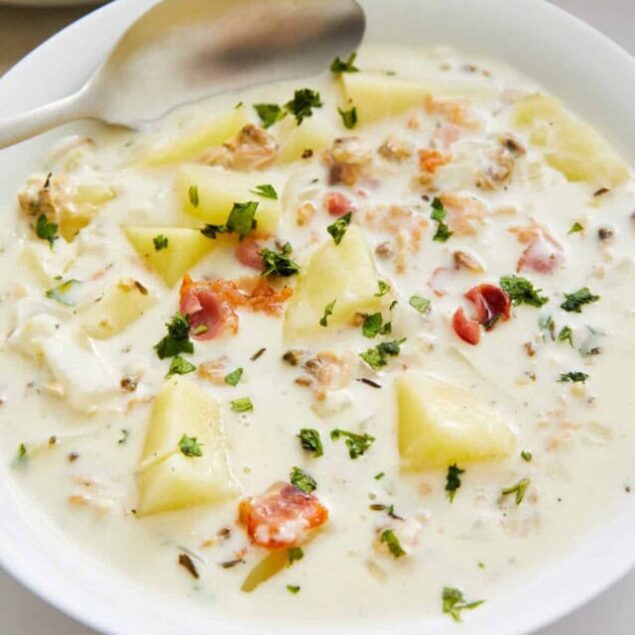 Creamy potato and bacon soup with fresh herbs, served in a white bowl, perfect for a hearty, healthy meal.