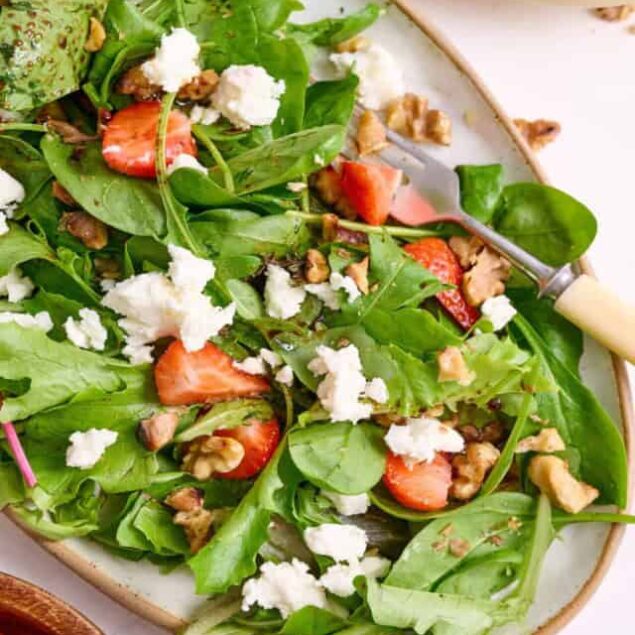 Fresh strawberry spinach salad with walnuts and crumbled feta cheese, perfect for healthy weight loss and nutritious meals.