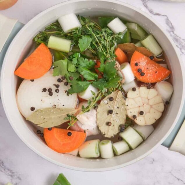 Fresh vegetable soup with carrots, garlic, celery, and herbs, perfect for healthy eating and detox, featuring nutritious ingredients for a wholesome meal.