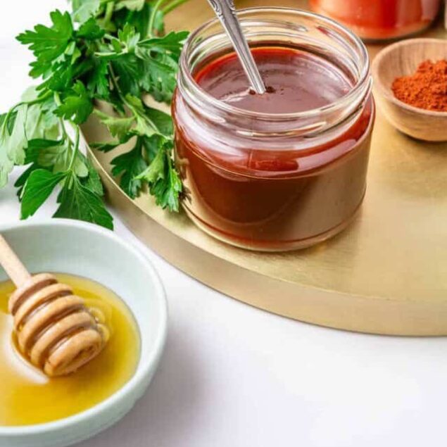 Rich honey and herbal tea in jars with fresh parsley and spices, healthy natural food ingredients for immune-boosting recipes.