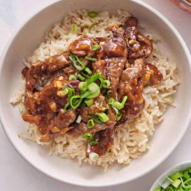 Savory beef stir-fry over white rice topped with chopped green onions, healthy and delicious meal perfect for meal prep or weeknight dinners.