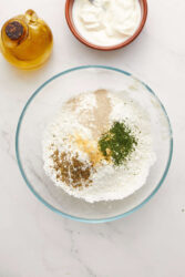 Whisking together gluten-free flour, yeast, and spices for gluten-free flatbread.