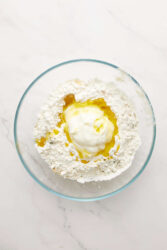 Adding yogurt and oil to dry ingredients for gluten-free flatbread.
