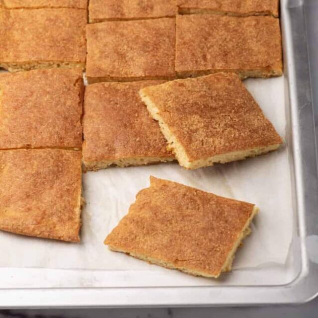 Golden brown homemade cornbread squares on a baking sheet, perfect for healthy comfort meals, gluten-free recipes, or meal prep. Enjoy warm, soft, and delicious cornbread with a crispy crust.