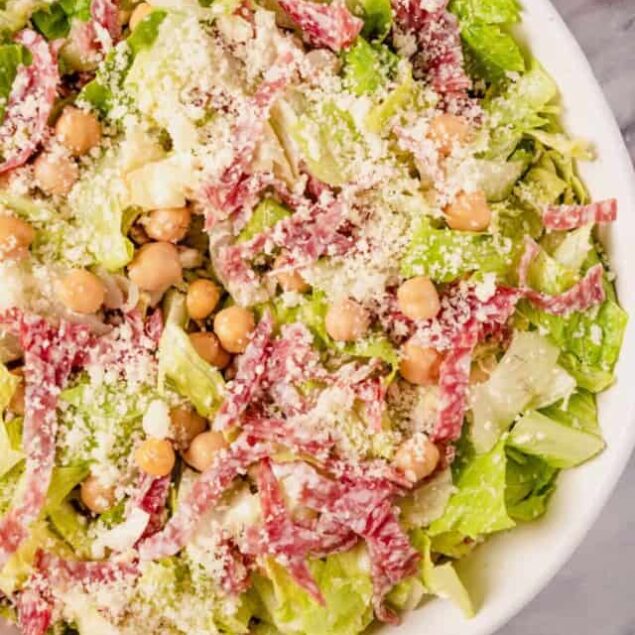 Fresh chickpea and shredded beef salad with lettuce and grated cheese, served in a white bowl. Healthy, protein-rich meal perfect for weight loss and nutritious meals.