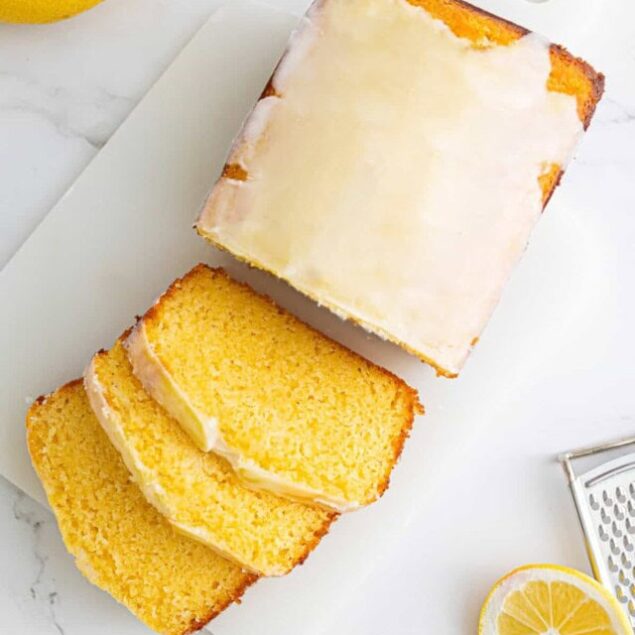Lemon cake with lemon glaze on white marble background, food photography.