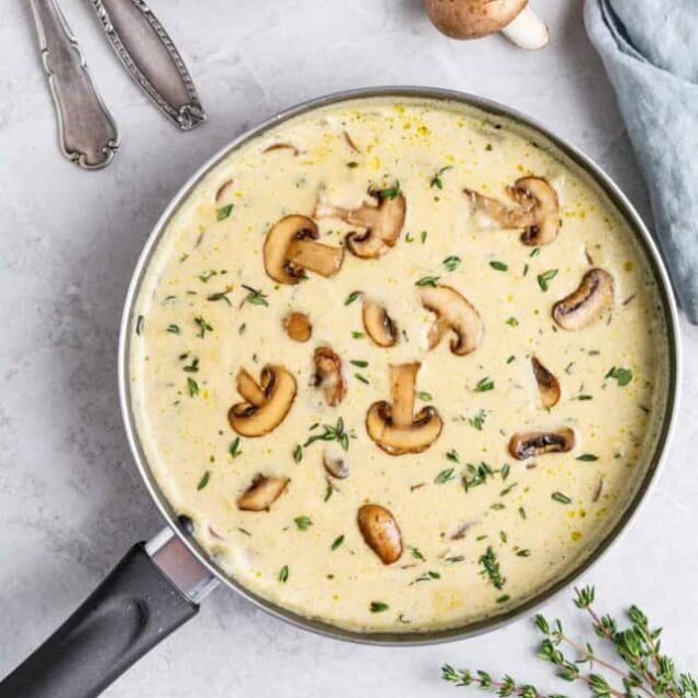 Creamy mushroom and herb sauce in a skillet, highlighting healthy cooking and flavorful ingredients.