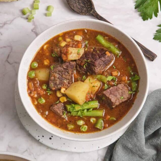 Hearty beef stew with vegetables and potatoes in a rich tomato broth, perfect for healthy meal prep and comfort food lovers.
