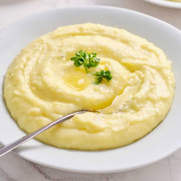 Creamy mashed potatoes with butter and herbs in a white bowl for healthy comfort food.