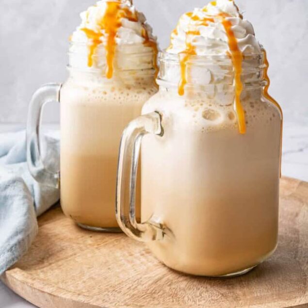 Creamy caramel frappuccino with whipped cream and caramel drizzle in glass mugs, perfect for a sweet treat or refreshing coffee drink. Ideal for coffee lovers and dessert enthusiasts.