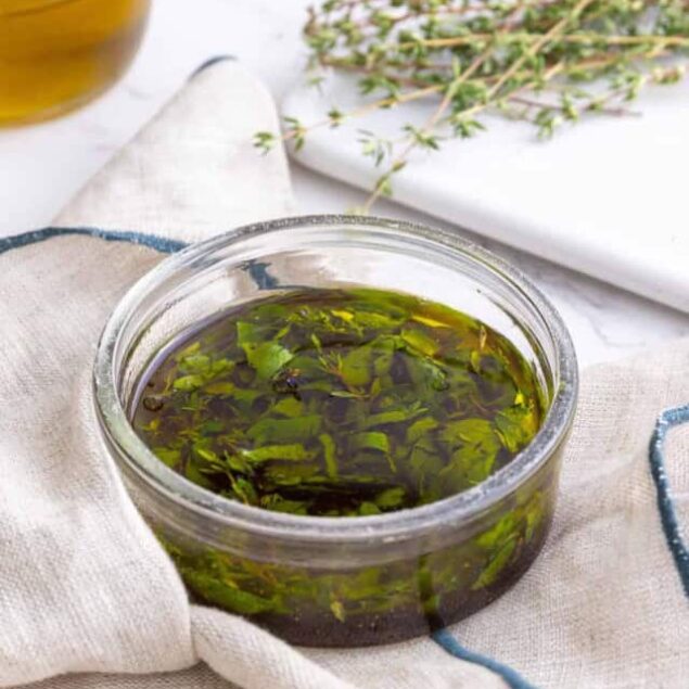 Fresh dried oregano leaves soaked in olive oil for healthy cooking and herbal remedies.